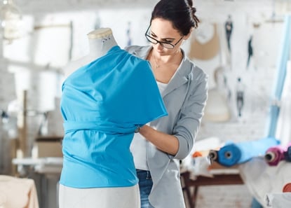 stock-photo-beautiful-woman-fashion-designer-working-with-tailoring-mannequin-trying-on-various-ornaments-1031742766