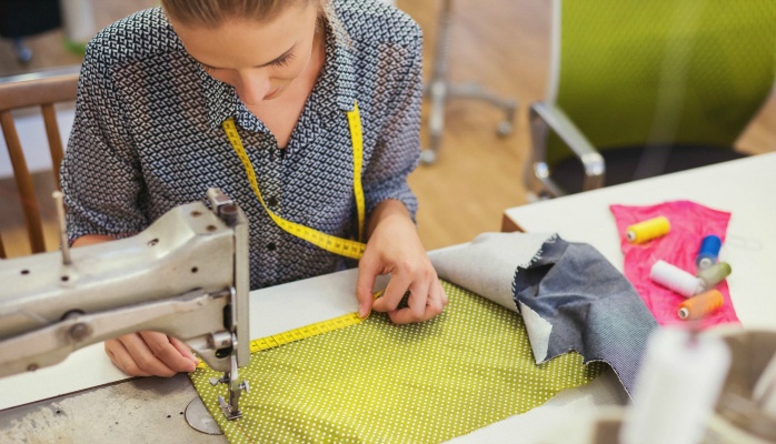 woman sewing green fabric